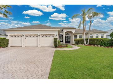 Charming single-story home boasting a three-car garage, manicured lawn, and tropical landscaping at 2877 Ashton Ter, Oviedo, FL 32765