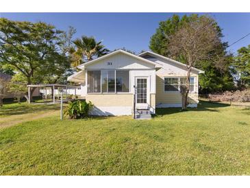 Charming single-story home with a screened porch and well-maintained front yard at 311 E Wallace St, Orlando, FL 32809