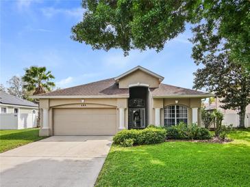 Charming single-story home featuring a manicured lawn, well-maintained landscaping, and a two-car garage at 405 Carriage Way Ct, Oviedo, FL 32765