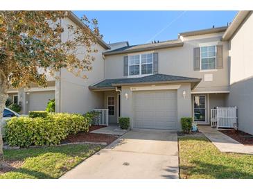 Charming townhome featuring a one car garage, covered entry and manicured landscaping at 435 Tradition Ln, Winter Springs, FL 32708