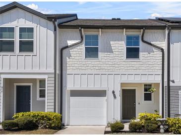 Charming townhome with white siding, a one-car garage, and well-maintained landscaping at 808 Grandin St, Davenport, FL 33837