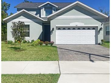 Charming two-story home with a well-manicured lawn and a two-car garage with a beautifully paved driveway at 827 Dennis Ave, Orlando, FL 32807