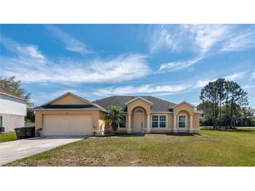 Inviting single story home featuring a manicured lawn, arched entry and two car garage at 935 Gloucester Court, Kissimmee, FL 34758