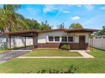 Charming single-story home with a carport and well-maintained front lawn in a residential area at 1103 Timor Ave, Orlando, FL 32804