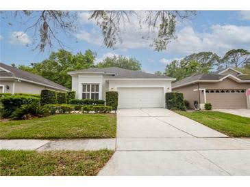 Well-maintained home featuring a two-car garage, manicured lawn, and trimmed hedges for curb appeal at 113 Golden Crest Ct, Winter Springs, FL 32708