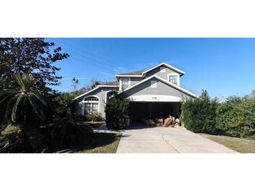 Charming two-story home featuring a well-maintained lawn and an attached two car garage at 115 Oxford Rd, Davenport, FL 33896