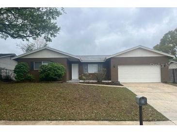 Inviting single-story home featuring a well-maintained lawn and an attached two-car garage at 1415 Meadowlark St, Longwood, FL 32750