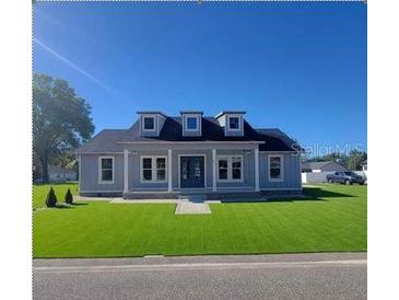 Charming single-story home featuring manicured lawn and symmetrical facade, all beneath a clear blue sky at 311 W Delaware Ave, Lake Helen, FL 32744