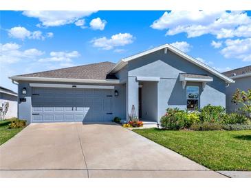 Beautiful one-story home with a well-manicured lawn, two car garage, and blue exterior at 312 Inman Blvd, Winter Haven, FL 33881