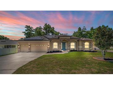 Beautiful single Gathering home featuring a well maintained lawn, solar panels, and a three car garage at 475 Pitt St, Clermont, FL 34711