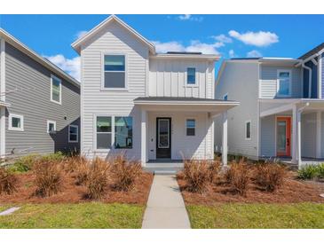 Charming white two-story home with a welcoming front porch and well-maintained landscaping at 6525 Rover Way, St Cloud, FL 34771