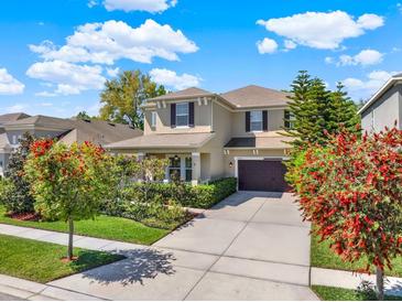 Beautiful two-story home with a well-manicured lawn, mature trees, and a spacious driveway at 7945 Pleasant Pine Cir, Winter Park, FL 32792