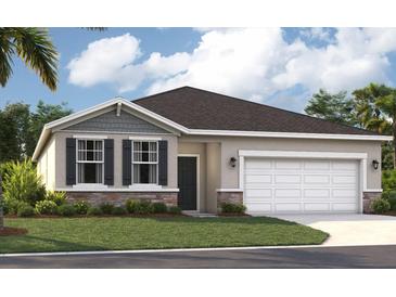 Charming single-story home with a well-manicured lawn, stone accents, and a two-car garage at 866 Pebble Crest Ln, Eagle Lake, FL 33839