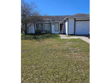 Charming single-story home featuring a well-maintained lawn, attached garage, and a welcoming entrance at 1510 Massa St, Kissimmee, FL 34744