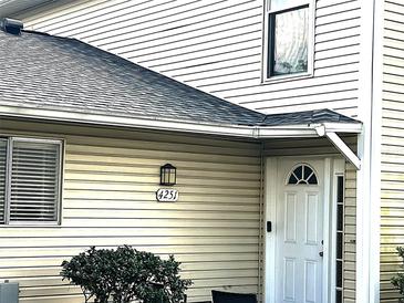 Charming front door with sidelight and address plate, complemented by neutral siding and neat landscaping at 4251 Pinebark Ave # 17-3, Orlando, FL 32811