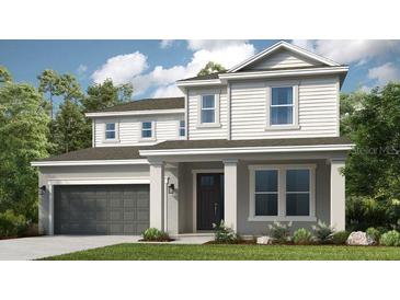 Inviting two-story home featuring a covered entryway, two-car garage, and manicured lawn at 4711 Coral Harbour Rd, Kissimmee, FL 34758