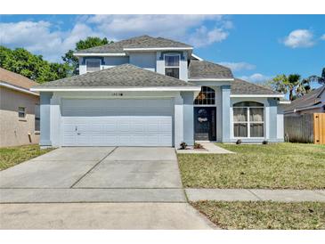 Charming two-story home features a two-car garage, manicured lawn, and inviting front entrance with decorative wreath at 12613 Maribou Cir, Orlando, FL 32828