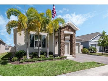 Charming single-Gathering home with stone accents, manicured lawn, and lush palm trees at 1807 Good Neighbor Loop, Kissimmee, FL 34744
