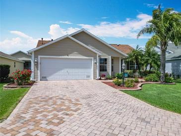 Charming single-story home with a brick-paved driveway, two-car garage, and beautifully landscaped front yard at 2124 Westchester Way, The Villages, FL 32162