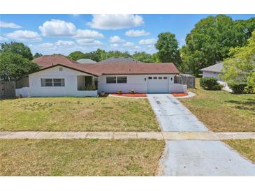 Charming single-story home with white brick, red roof, and well-maintained front lawn at 2240 Archer Blvd, Orlando, FL 32833