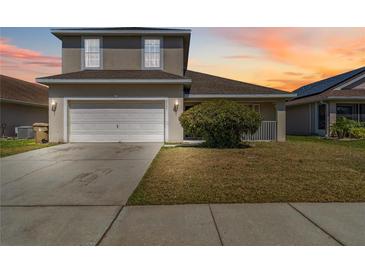 Charming two-story home featuring a two-car garage, well-maintained lawn and beautiful sky at 2723 Callaway Ln, Kissimmee, FL 34744