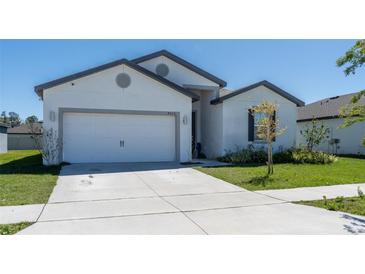 Charming single-story home features a two-car garage, a well-manicured lawn, and a concrete driveway at 4316 Carrabelle River Ln, Lakeland, FL 33811