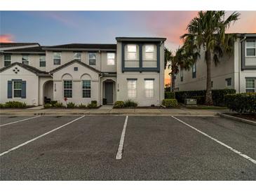 Modern townhome with neutral paint, blue accents, palm trees and parking at 482 Captiva Dr, Davenport, FL 33836