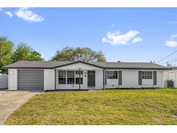 Charming single-story home featuring a well-manicured lawn and a freshly painted exterior at 822 Oakview Dr, New Smyrna Beach, FL 32169