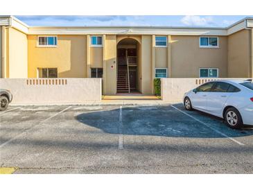 Condo building featuring designated parking, painted in inviting warm colors, and a welcoming entrance at 1000 Lake Of The Woods Blvd # 103H, Casselberry, FL 32730