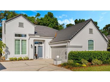 Charming home featuring gray roofing, a gray front door, an attached garage, and landscaped front yard at 1188 Brampton Pl, Lake Mary, FL 32746