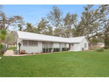 Charming single-story home featuring a well-manicured lawn and a screened porch at 1704 15Th St, Orange City, FL 32763