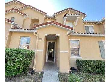 Inviting home entrance with well-manicured landscaping and neutral exterior paint scheme at 2651 Andros Ln, Kissimmee, FL 34747