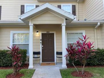 Inviting condo entrance with a well-maintained lawn, covered porch, and attractive front door at 2964 Lucayan Harbour Circ # 106, Kissimmee, FL 34746
