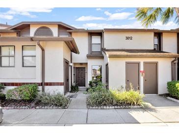 Charming townhouse featuring a well-maintained exterior, lush landscaping, and assigned parking at 3012 S Semoran Blvd # 3, Orlando, FL 32822