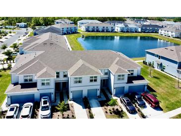 Beautiful townhomes featuring garages, driveways, and a scenic pond in a well-maintained community at 4512 Sparkling Shell Ave, Kissimmee, FL 34746
