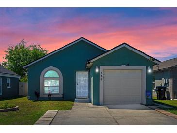 Charming home featuring a garage and well-maintained lawn, with a beautiful sunset sky in the background at 536 Southern Charm Dr, Orlando, FL 32807