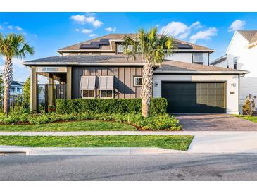 Beautiful two-story home featuring a dark gray two-car garage, solar panels, and manicured landscaping at 6439 Trailblaze Bnd, St Cloud, FL 34771