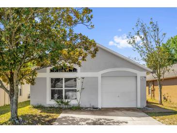 Charming single-story home with a well-maintained lawn and attached one-car garage on a sunny day at 205 Twisting Trl, Orlando, FL 32825