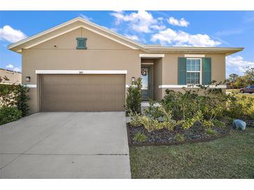 Charming single-story home with a well-manicured lawn and a two-car garage at 2451 Spring Breeze Dr, Leesburg, FL 34748