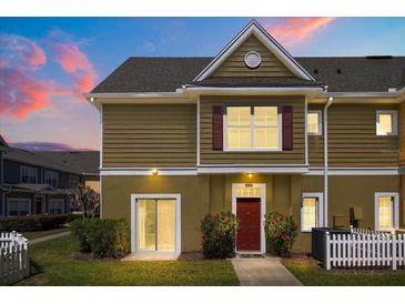 Charming townhome with a well-maintained lawn and a vibrant red front door, creating an inviting curb appeal at 2624 Lodi Cir # 101, Kissimmee, FL 34746