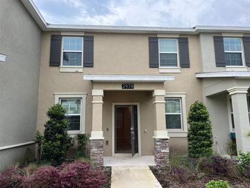 Inviting two-story townhome featuring stone accents and a covered entry at 2978 Aqua Virgo Loop # 13, Orlando, FL 32837