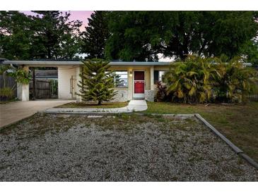 Charming single-story home featuring a red front door and a well-maintained, rock landscaped front yard at 6031 W Ridgewood Ave, Orlando, FL 32835