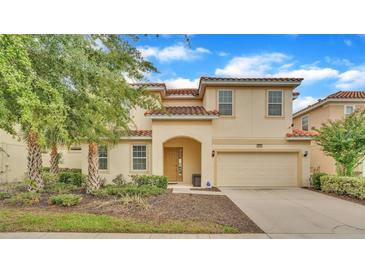 Charming two-story home featuring a red tile roof, arched entry, and attached two-car garage at 7012 Oakwood St, Davenport, FL 33837