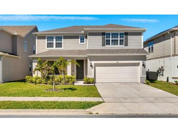 Charming two-story home featuring a manicured lawn, a two-car garage, and tasteful landscaping at 7633 Agrigento St, Clermont, FL 34714