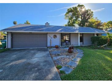 Charming single-story home featuring a gray facade, well-maintained lawn, and an attached two-car garage at 1019 Chippewa Trl, Daytona Beach, FL 32117