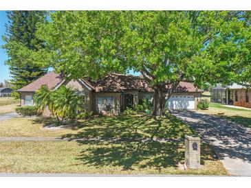 Charming brick home with a large, mature tree providing ample shade and curb appeal at 20705 Nettleton St, Orlando, FL 32833