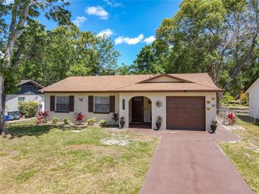 Charming, one-story home with a brick exterior, front lawn, and a driveway leading to an attached garage at 2617 S Marshall Ave, Sanford, FL 32773