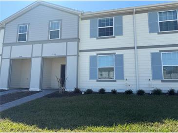 Charming two-story townhome featuring light blue shutters and a well-manicured lawn on a sunny day at 3990 Lana Ave, Davenport, FL 33897