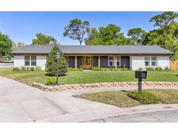 Charming single-story home with beautifully landscaped front yard, updated paint, and inviting entrance at 400 Royal Palm Ct, Longwood, FL 32779