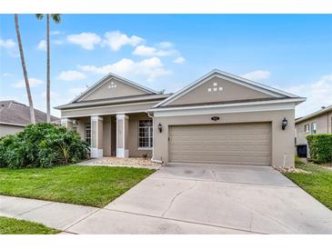 Tan home with a well-manicured lawn and two-car garage provides great curb appeal at 10176 Hart Branch Cir, Orlando, FL 32832